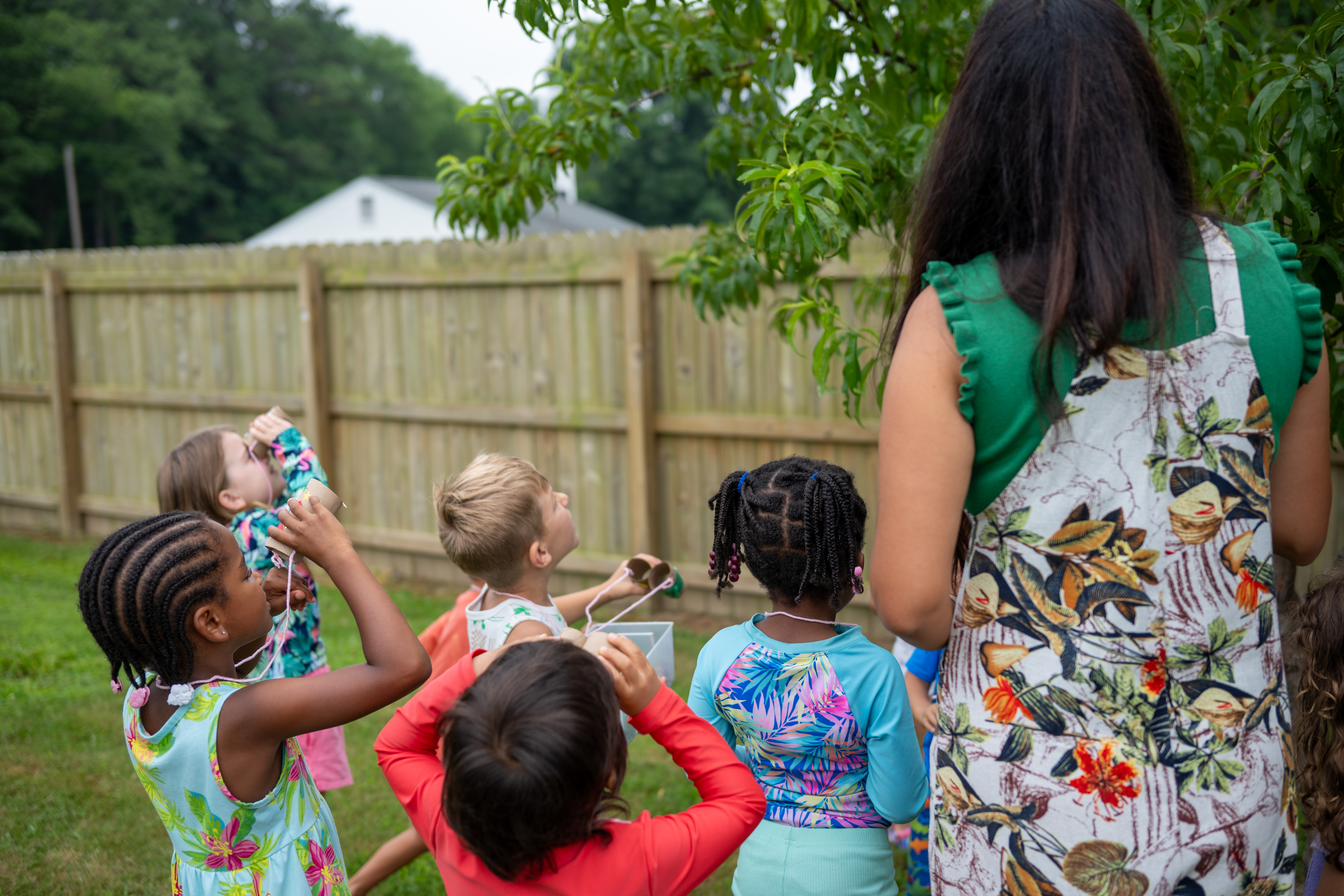 kids using binoculars to look at fruit tree